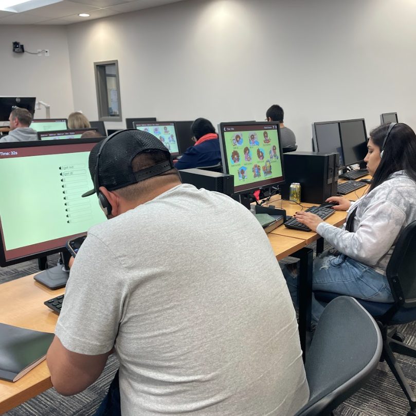 ESOL students learning at computers.